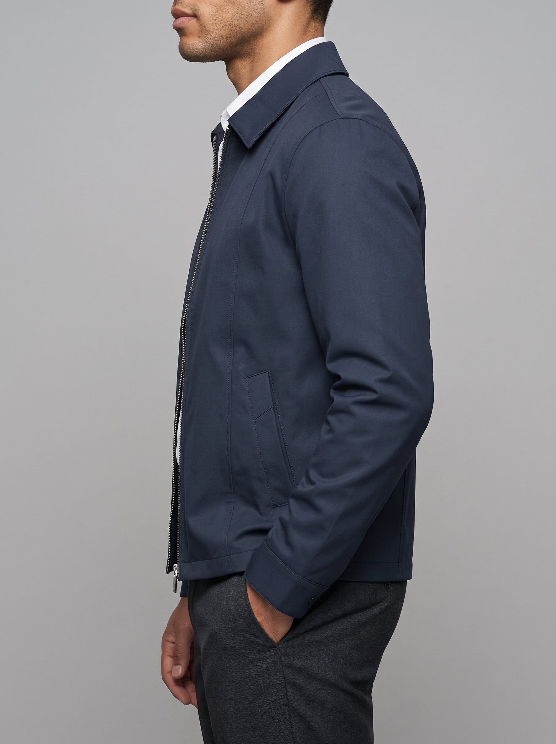 A man viewed from the profile wearing a navy blue jacket