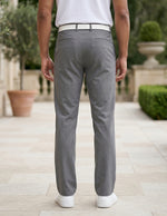 Back view of male model wearing gray tailored casual pants with a white polo shirt.