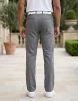 Back view of male model wearing gray tailored casual pants with a white polo shirt.
