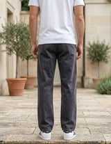 Back view of male model wearing charcoal gray relaxed-fit casual pants with a white T-shirt.