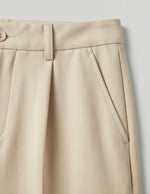 Beige pleated skirt on a light gray background