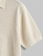 Beige ribbed knit sweater on a gray background