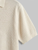 Beige ribbed knit sweater on a gray background