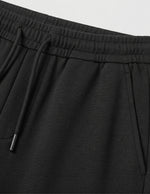 Black men’s lightweight drawstring pants with elastic waistband and clean casual fit close-up details
