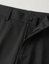 Black men’s pleated tailored pants with clean front closure and straight fit close-up details