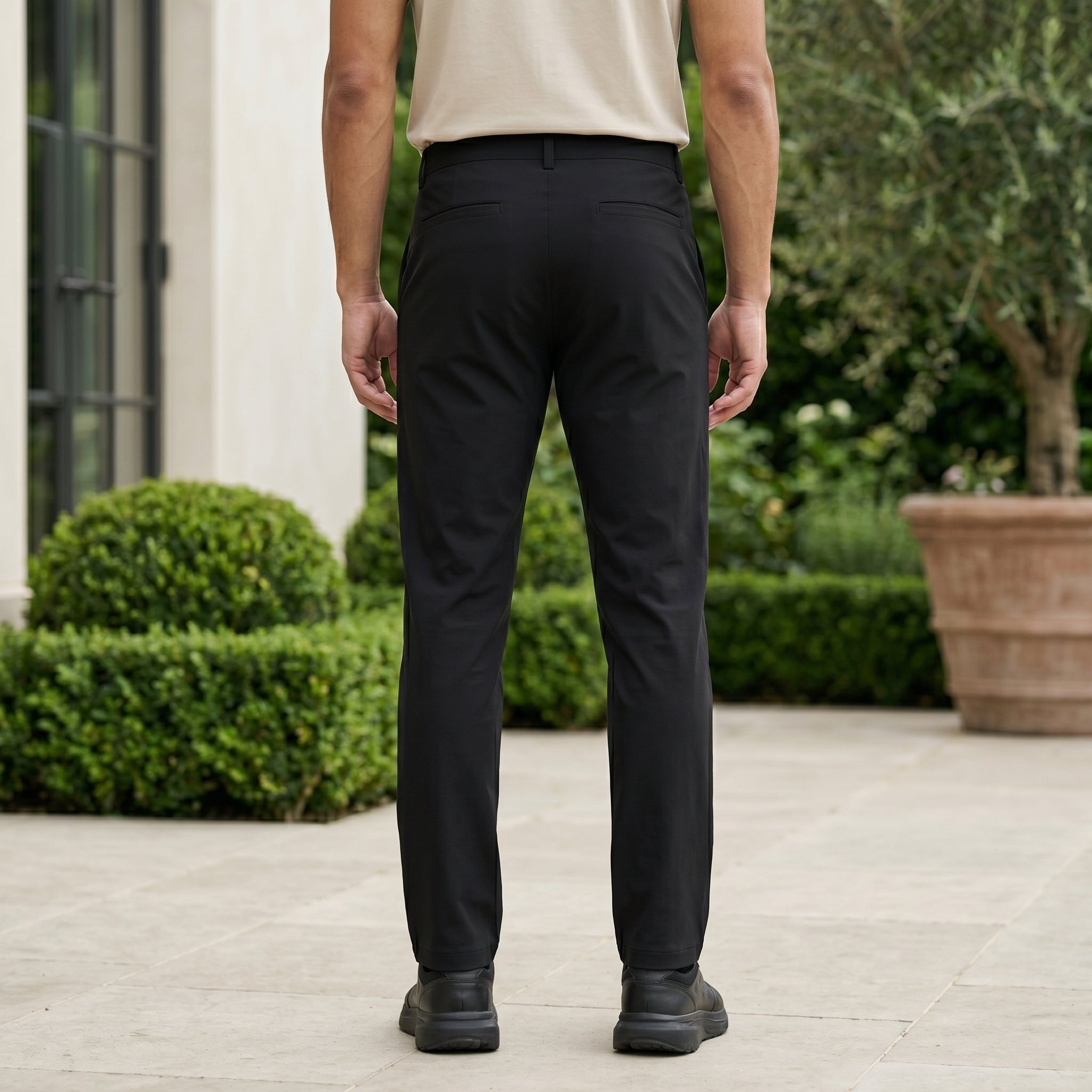 Black men’s stretch pocketed pants with clean straight fit and button-front closure back view