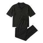 Black textured short-sleeve shirt with matching straight-leg pants on a white background.