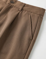 Brown men’s pleated pocketed trousers with button waistband close-up