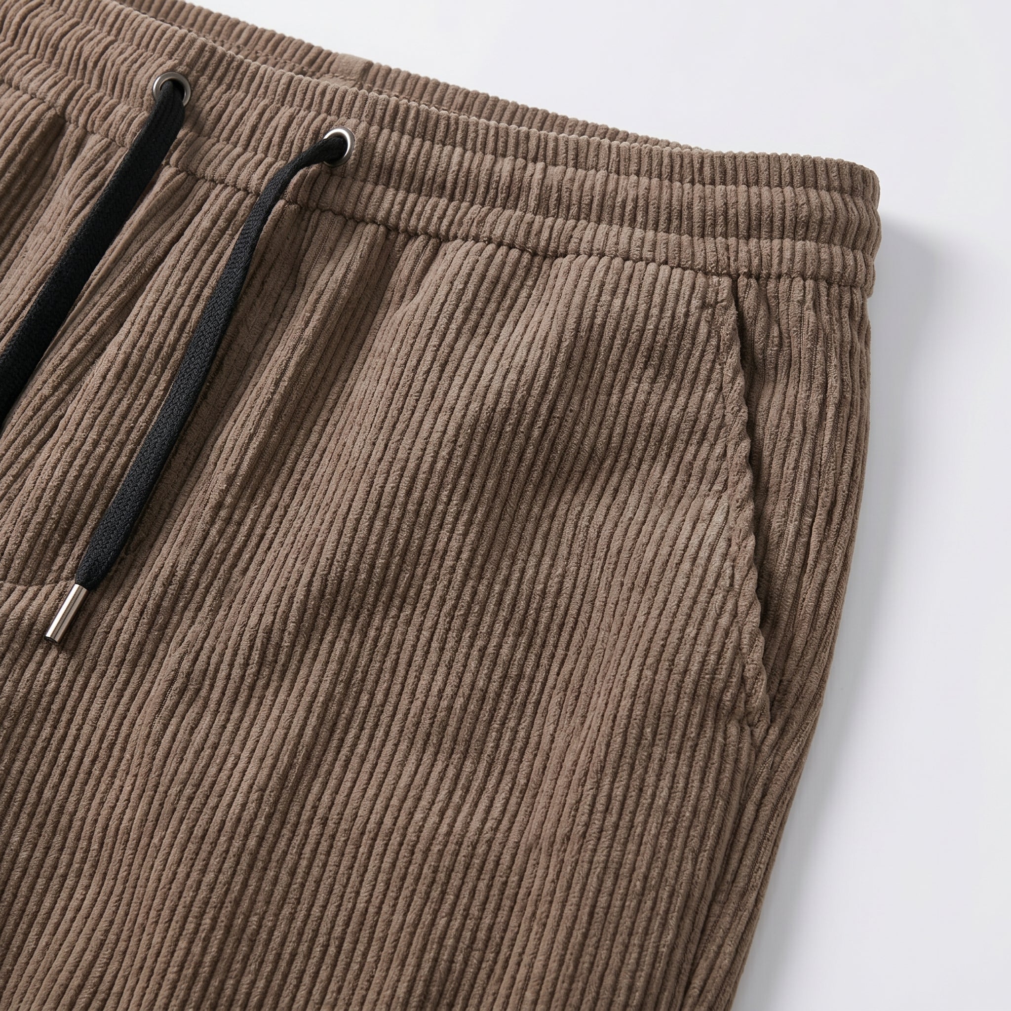 Brown men’s ribbed drawstring pants with elastic waistband and side pockets close-up details