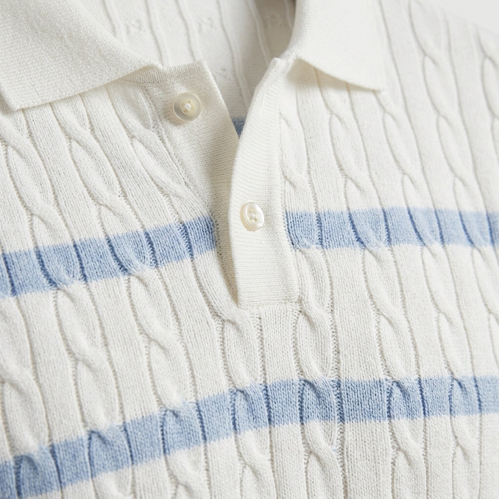 Celeste - Close-up of a white cable knit sweater with blue stripes and buttons.