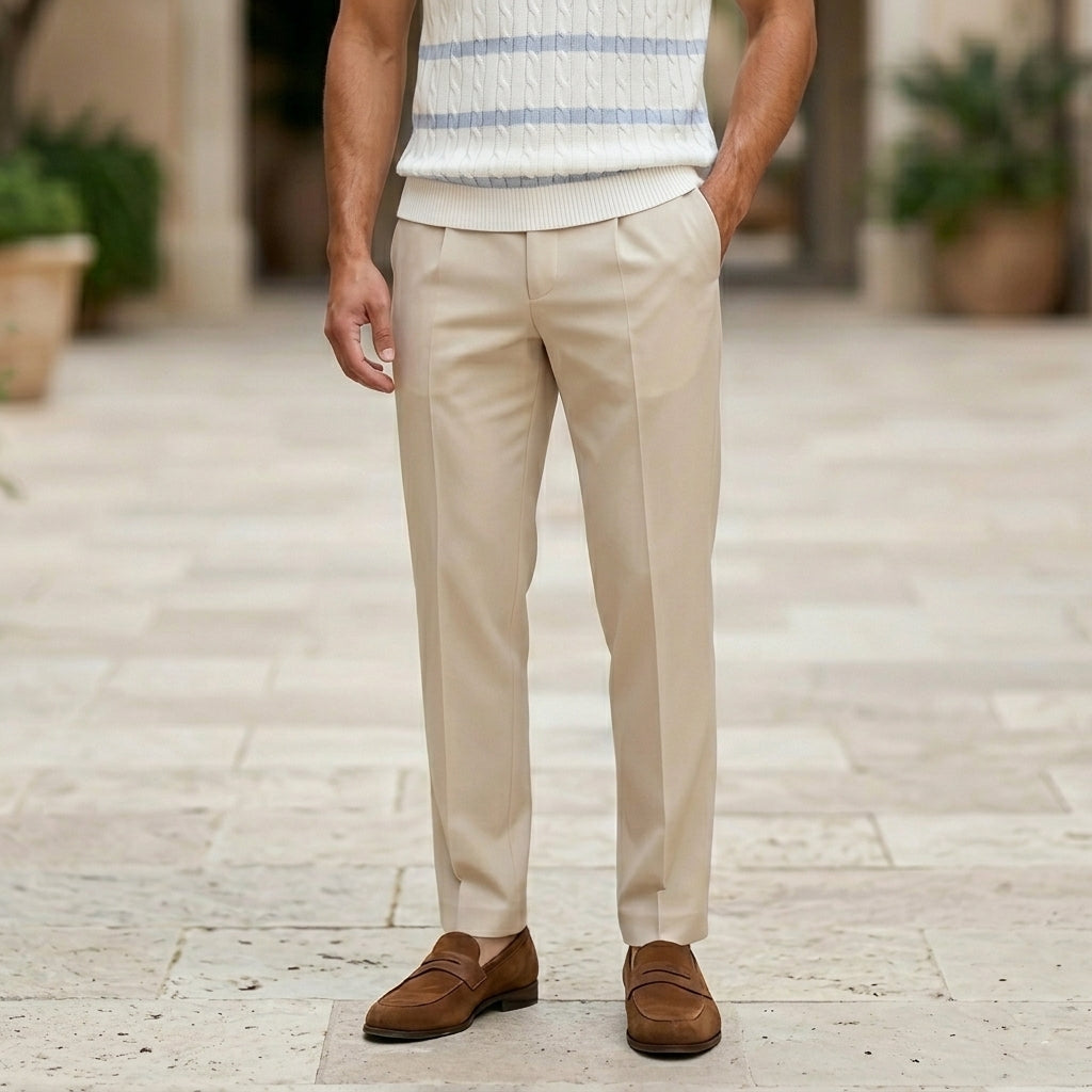 Celeste  - Person wearing beige pants and brown shoes on a stone pavement.