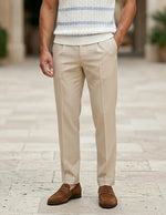Celeste  - Person wearing beige pants and brown shoes on a stone pavement.