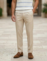 Celeste  - Person wearing beige pants and brown shoes on a stone pavement.