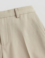 Close-up of beige pants on a light gray background