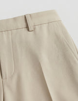 Close-up of beige pants on a light gray background