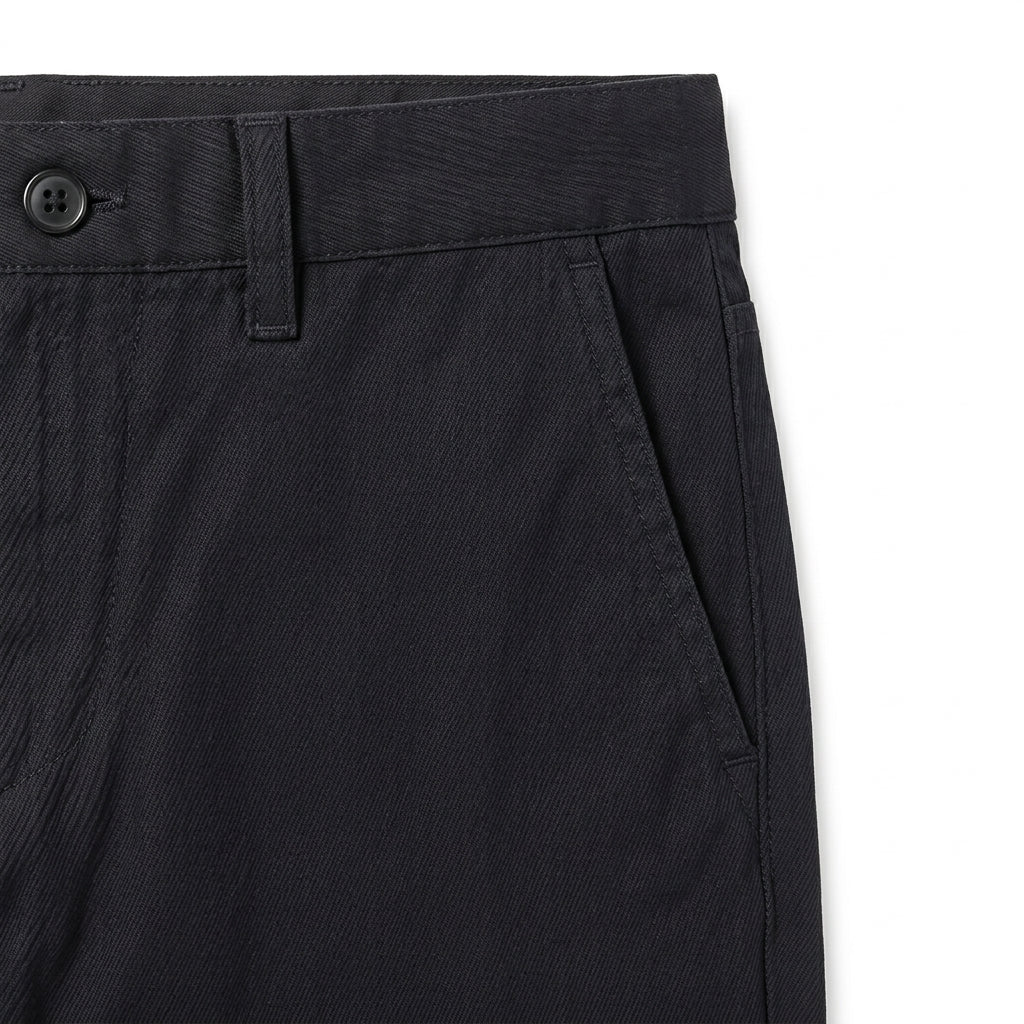 Close-up detail of black casual pants waistband, button closure, and soft fabric.