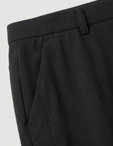 Close-up detail of black casual pants waistband, side pocket, and smooth fabric.