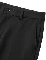 Close-up detail of black tailored pants waistband with belt loops, button closure, and smooth fabric.