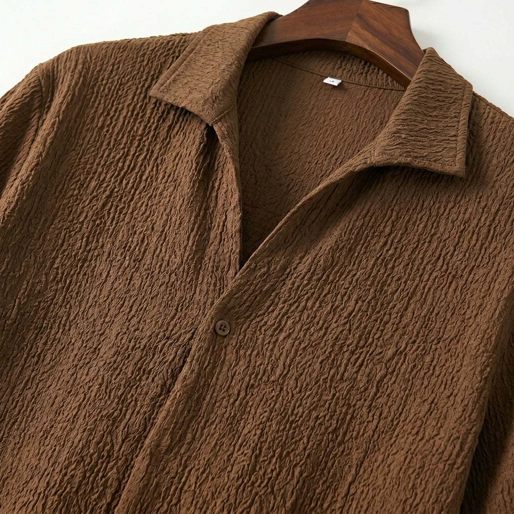 Close-up detail of brown textured short-sleeve shirt fabric and collar.