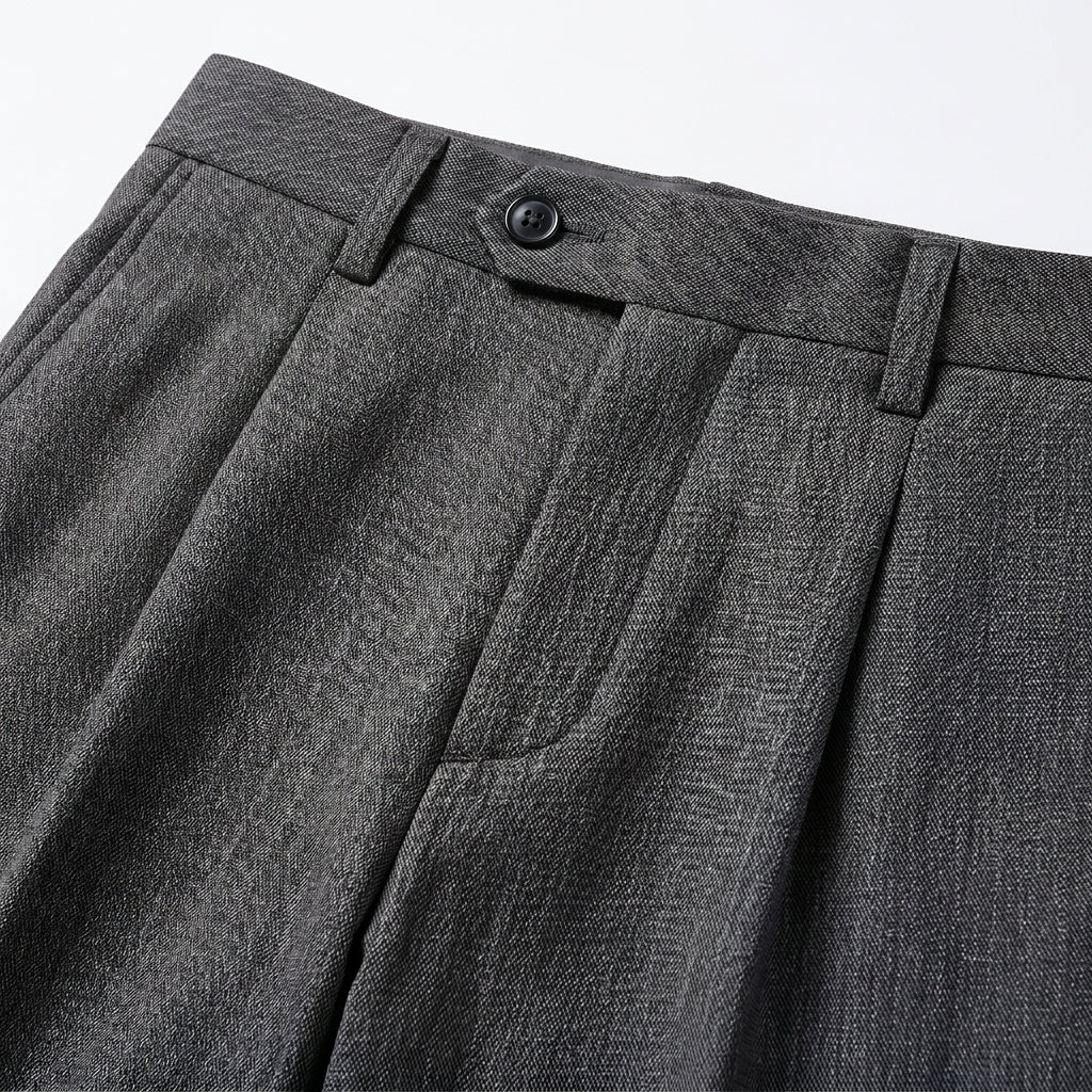 Close-up detail of dark gray tailored pants fabric, pocket, and clean seam finish.