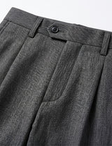 Close-up detail of dark gray tailored pants fabric, pocket, and clean seam finish.