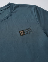 Close-up detail of dark teal blue T-shirt fabric with crew neckline and subtle chest logo.