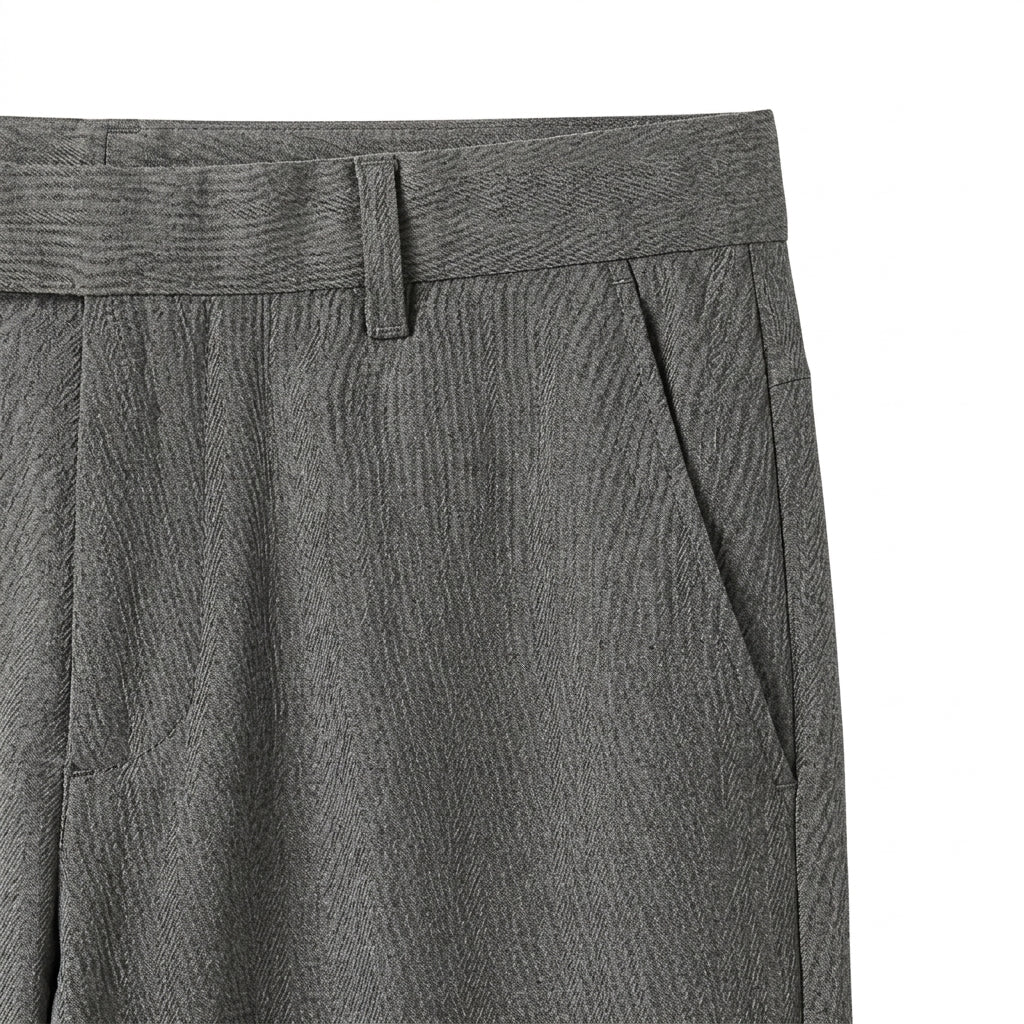 Close-up detail of gray tailored pants waistband, side pocket, and smooth fabric.