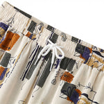 Close-up detail of ivory abstract print drawstring shorts with elastic waistband and white rope tie.