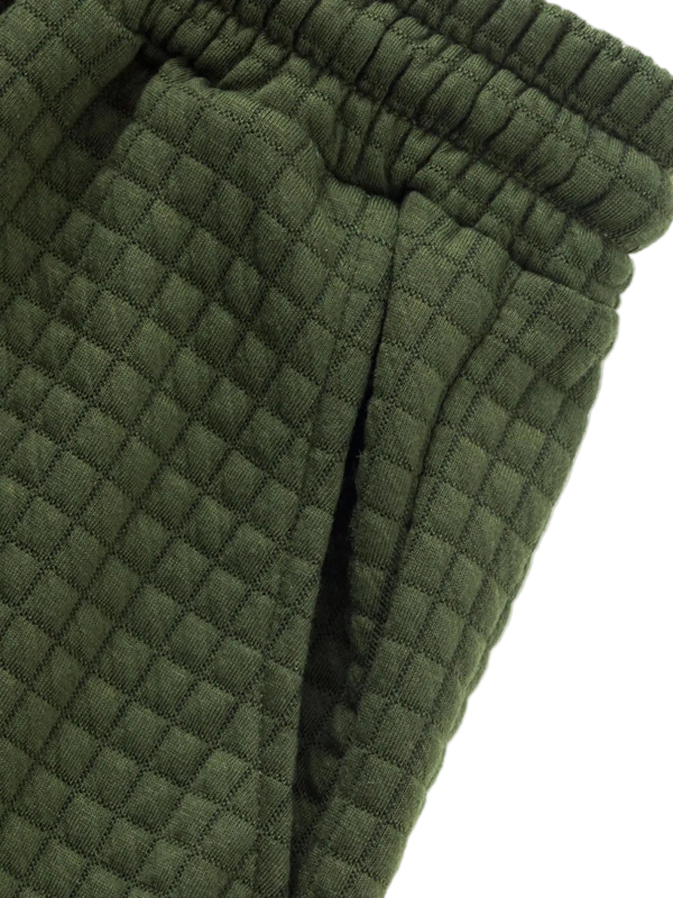 Close-up detail of olive green textured drawstring shorts with elastic waistband and white rope tie.