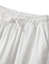 Close-up detail of white drawstring pants with elastic waistband and soft textured fabric.