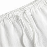 Close-up detail of white relaxed-fit pants waistband with soft textured fabric.