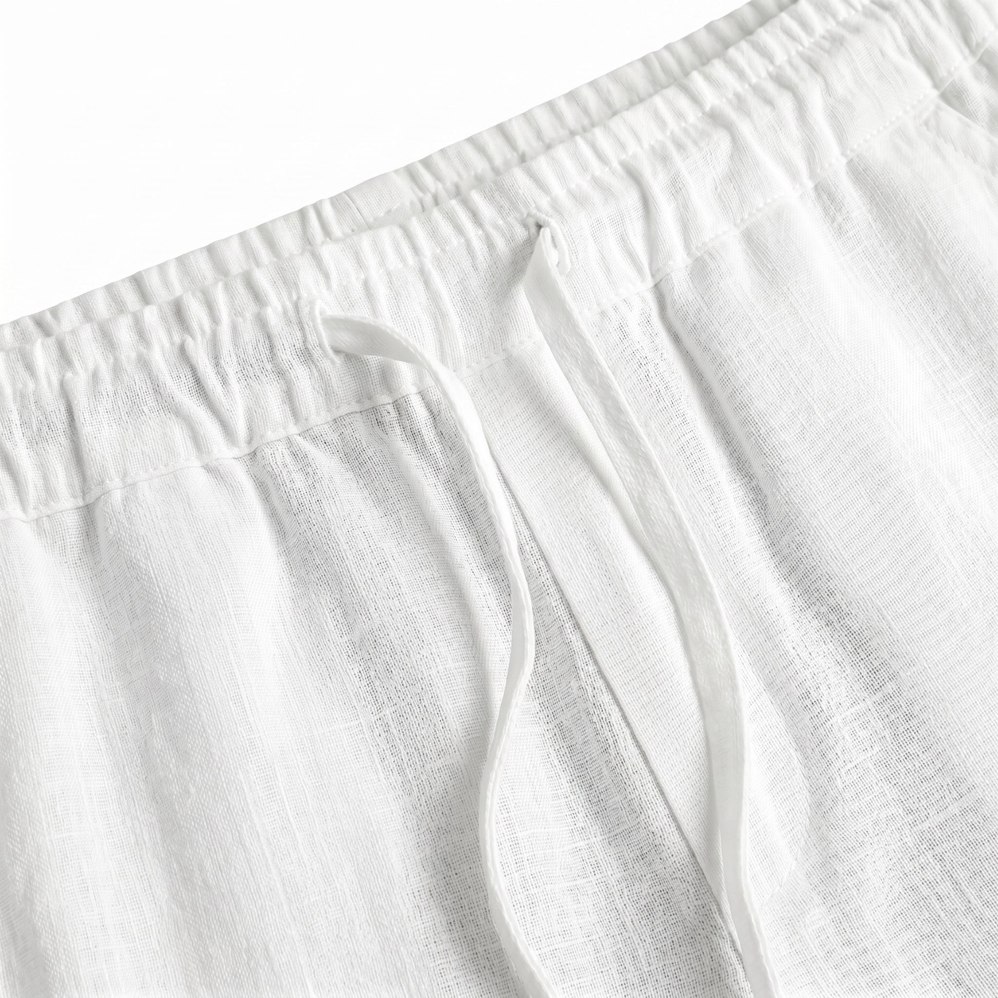 Close-up detail of white relaxed-fit pants waistband with soft textured fabric.