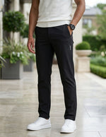 Close-up front view of male model wearing black casual pants with a tapered straight-leg fit.