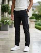 Close-up front view of male model wearing black casual pants with a tapered straight-leg fit.