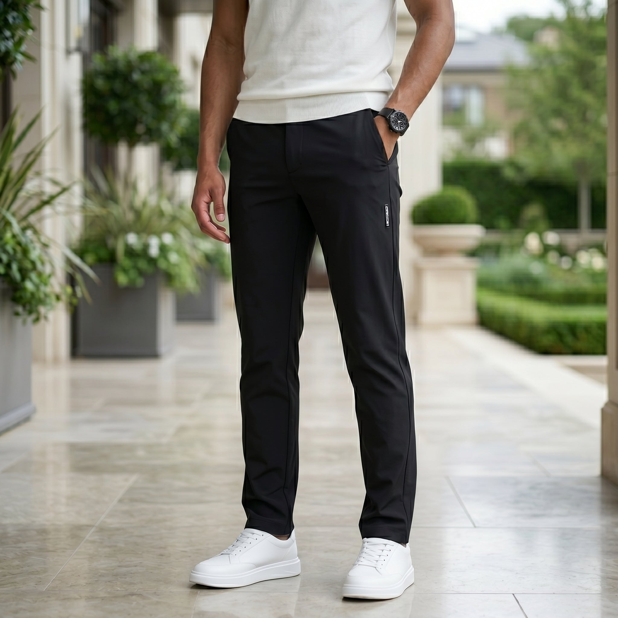 Close-up front view of male model wearing black casual pants with a tapered straight-leg fit.
