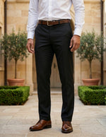 Close-up front view of male model wearing black tailored dress pants with a slim straight-leg fit.