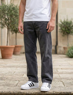 Close-up front view of male model wearing charcoal gray relaxed-fit casual pants with a straight-leg fit.