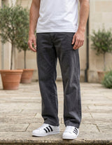 Close-up front view of male model wearing charcoal gray relaxed-fit casual pants with a straight-leg fit.