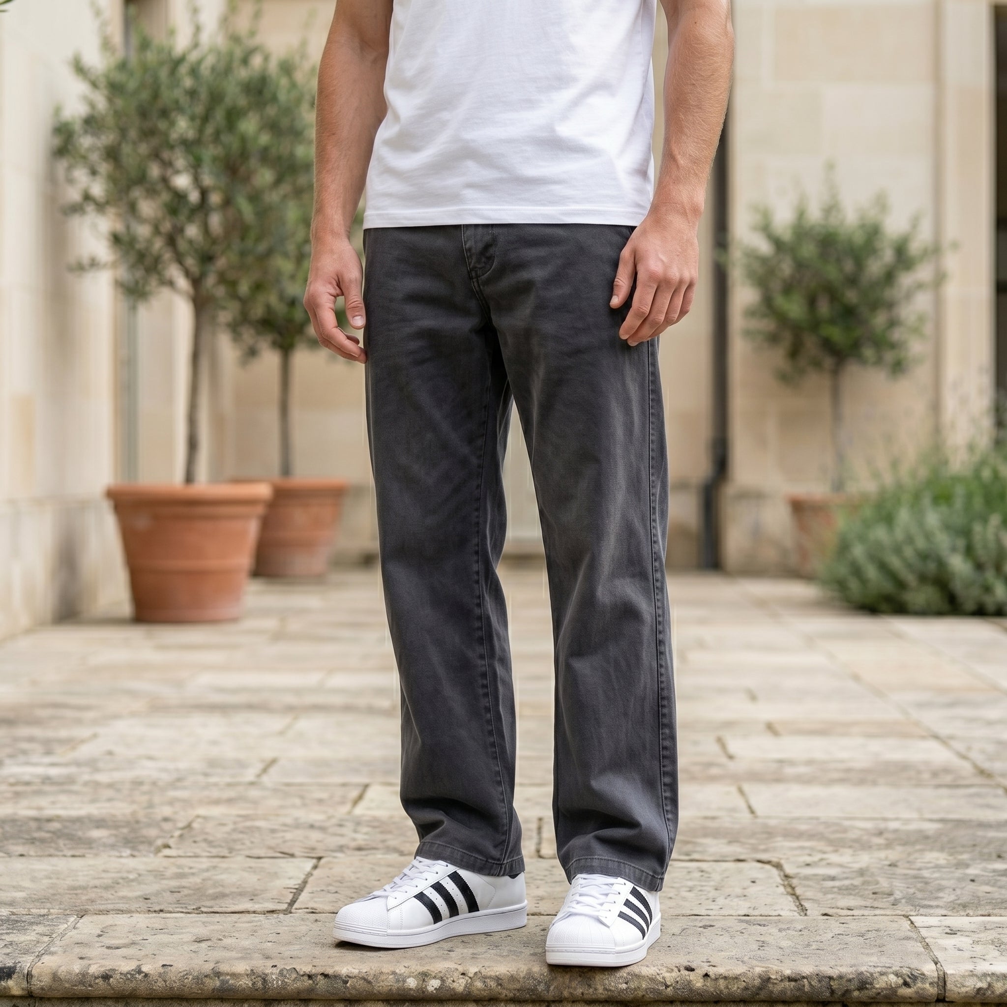 Close-up front view of male model wearing charcoal gray relaxed-fit casual pants with a straight-leg fit.