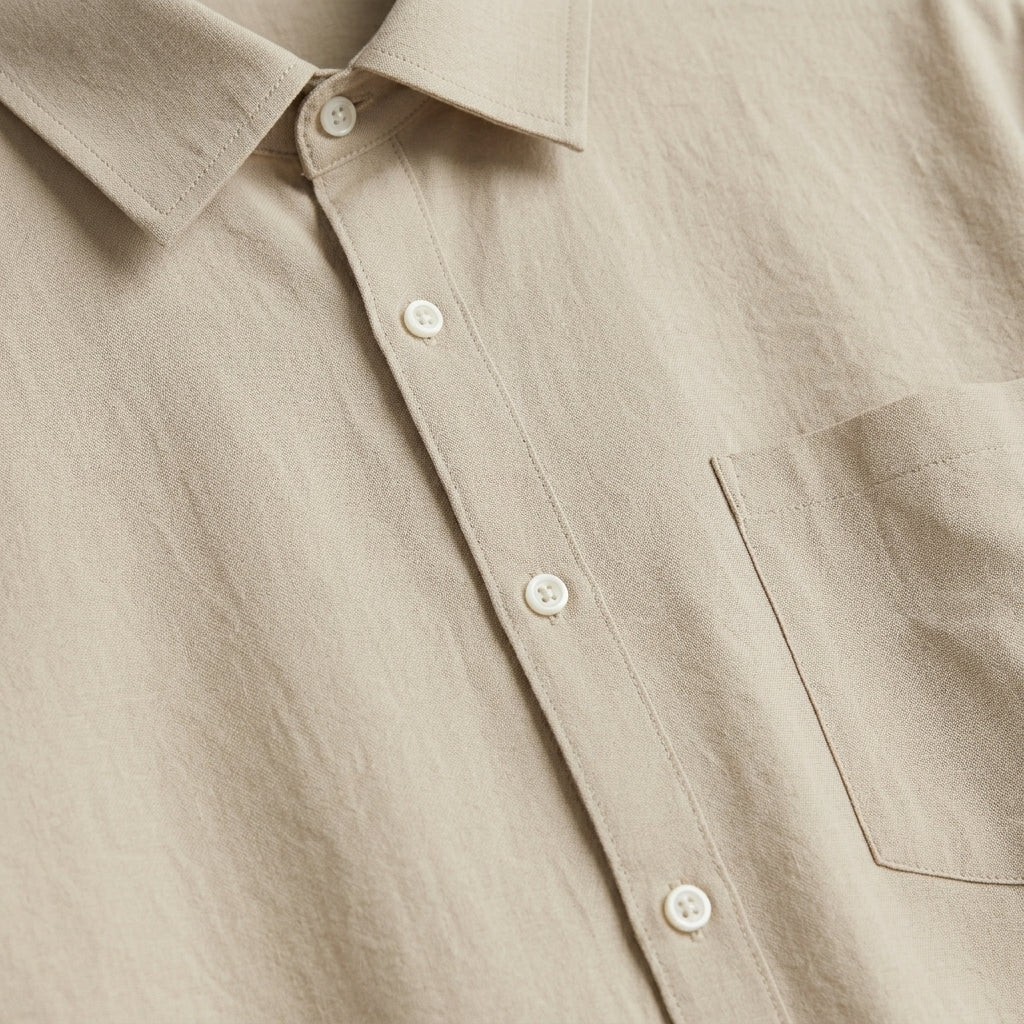 Close-up of a beige button-up shirt with a pocket.