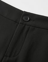 Close-up of a black button on a black garment against a light gray background