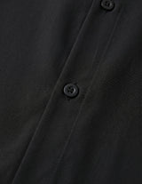 Close-up of a black buttoned shirt with a focus on texture and buttons.