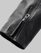 Close-up of a black leather jacket with a zipper on a grey background