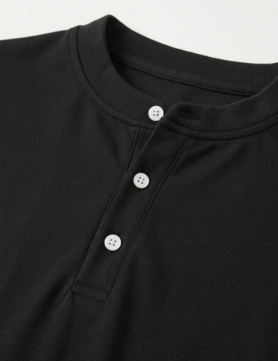 Close-up of a black shirt with button details on a light gray background