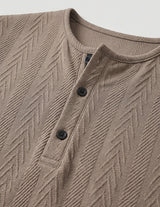 Close-up of a brown textured shirt with buttons on a light gray background