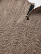 Close-up of a brown textured sweater with a patterned design.