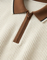 Close-up of a brown zipper on a textured beige fabric background