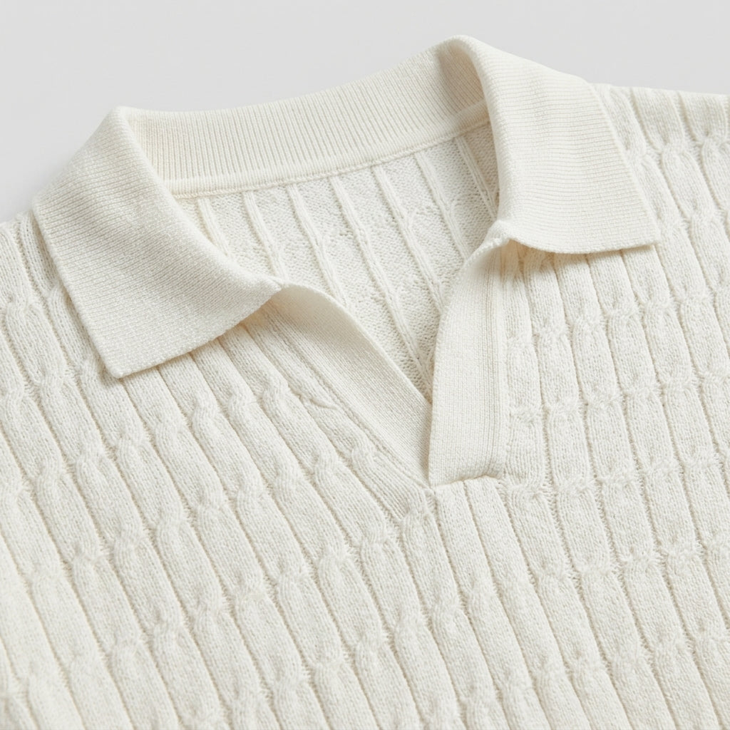 Close-up of a cream-colored ribbed sweater with a collar on a light gray background