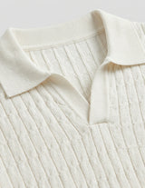 Close-up of a cream-colored ribbed sweater with a collar on a light gray background