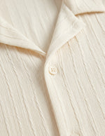 Close-up of a cream-colored shirt with buttons